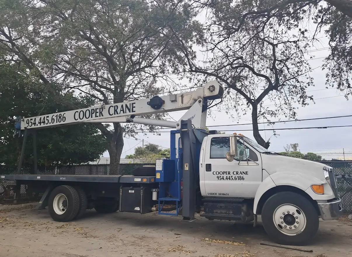 Cooper Crane boom truck set up at a residential job for a pest control tarp lift