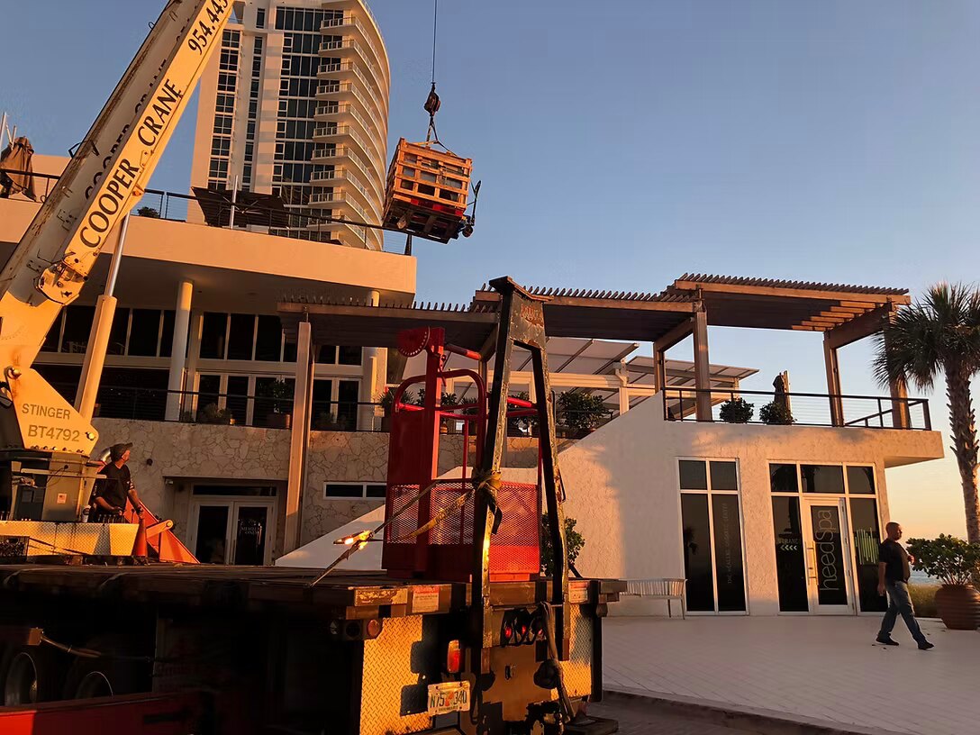 Cooper Crane boom truck setting a rooftop AC unit in Southeast Florida
