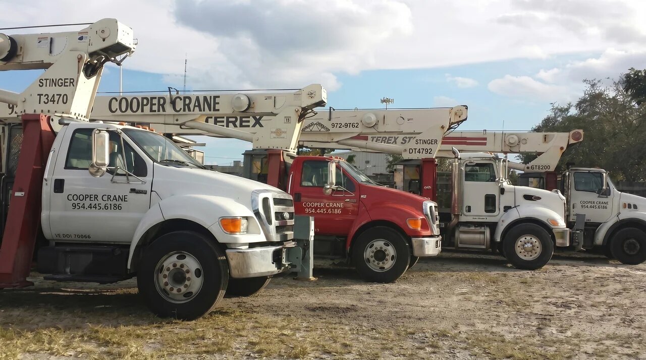 Cooper Crane fleet staged at the West Park yard: spider crane, boom trucks and 40-ton mobile crane